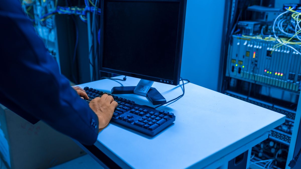 Técnico configurando equipamento em sala de rede